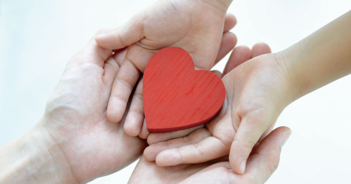ひとり親女性を支援するために、大人と子どもがハートを手渡しているイメージ
